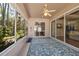Screened patio with a ceiling fan, and a view of the surrounding greenery at 5492 Legend Hills Ln, Spring Hill, FL 34609