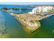 Waterfront condo building surrounded by picturesque bay waters, a peninsula, and nearby amenities at 5915 Sea Ranch Dr # 211, Hudson, FL 34667