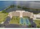 Fantastic aerial view of condo building complex with tennis courts, ample parking, and lush landscaping throughout at 5915 Sea Ranch Dr # 211, Hudson, FL 34667