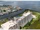 Breathtaking aerial view of condo building with water views, tennis court, ample parking, and gorgeous landscape at 5915 Sea Ranch Dr # 211, Hudson, FL 34667