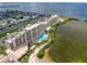 Beautiful aerial view of white condo building with pool, waterfront, and stunning landscape and surrounding neighborhood at 5915 Sea Ranch Dr # 211, Hudson, FL 34667