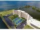 Desirable aerial view of condo community with tennis courts, ample parking, lush landscaping, and waterfront access at 5915 Sea Ranch Dr # 211, Hudson, FL 34667