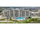 Beautiful condo building featuring a pool with surrounding lounge chairs and landscaped greenery at 5915 Sea Ranch Dr # 211, Hudson, FL 34667