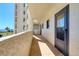 A hallway with beige siding leading to a doorway with water views in the background at 5915 Sea Ranch Dr # 211, Hudson, FL 34667