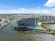 Scenic aerial of waterfront condos featuring a swimming pool under bright blue skies and fluffy clouds at 6035 Sea Ranch Dr # 408, Hudson, FL 34667