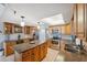 An open concept kitchen features oak cabinets, stainless appliances, granite counters and an island at 6035 Sea Ranch Dr # 408, Hudson, FL 34667