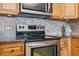 A stainless steel oven is surrounded by tile backsplash and wood cabinets at 6035 Sea Ranch Dr # 408, Hudson, FL 34667