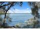 A beautiful view of the water from the shoreline framed by lush greenery at 6035 Sea Ranch Dr # 408, Hudson, FL 34667