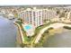 Aerial waterfront view featuring the condo building, pool, and waterfront views at 6035 Sea Ranch Dr # 411, Hudson, FL 34667