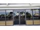 Building entrance featuring double glass doors with decorative logos and views of the parking area at 6035 Sea Ranch Dr # 411, Hudson, FL 34667