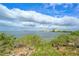 Enjoy this gorgeous waterfront view from a grassy lawn with mature bushes and scenic horizons at 6035 Sea Ranch Dr # 411, Hudson, FL 34667