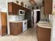 Kitchen with stainless steel refrigerator, white appliances, and wood cabinetry at 6361 Boxwood St, Brooksville, FL 34602