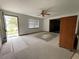 Open living room with neutral carpet, a ceiling fan, and a bright open doorway at 6361 Boxwood St, Brooksville, FL 34602