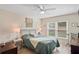Comfortable bedroom with ceiling fan, side tables, and a view of the green space outside at 6440 Spring Flower Dr # 11, New Port Richey, FL 34653