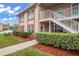 Inviting condo exterior with a staircase, lush shrubbery, and mulch landscaping at 6440 Spring Flower Dr # 11, New Port Richey, FL 34653