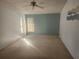 Bright bedroom featuring a ceiling fan, neutral carpet, and natural light through the windows at 7125 Silverwood Dr, New Port Richey, FL 34654
