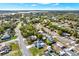 An aerial view showcases the lush neighborhood and surrounding landscape with mature trees and nearby lake at 7205 Pinehurst Dr, Spring Hill, FL 34606