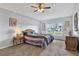 Cozy bedroom featuring plush carpeting, ceiling fan and a large window for ample natural light at 7205 Pinehurst Dr, Spring Hill, FL 34606