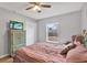 Bright bedroom features a ceiling fan, closet, television and large window at 7205 Pinehurst Dr, Spring Hill, FL 34606