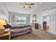 Bedroom featuring plush carpeting, ceiling fan and a large window for ample natural light at 7205 Pinehurst Dr, Spring Hill, FL 34606