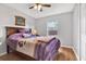 Inviting bedroom with wood floors, ceiling fan and large window offering a serene view of the outdoors at 7205 Pinehurst Dr, Spring Hill, FL 34606