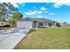 Charming single-story home featuring a well-maintained lawn, attached two-car garage, and long private drive at 7205 Pinehurst Dr, Spring Hill, FL 34606