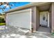 Exterior view of the garage, front door and landscaping at 7205 Pinehurst Dr, Spring Hill, FL 34606