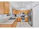 Bright kitchen with stainless steel appliances, light wood cabinets, and tiled flooring at 7205 Pinehurst Dr, Spring Hill, FL 34606