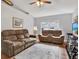Comfortable living room showcasing two sofas, a ceiling fan, and bright natural light at 7205 Pinehurst Dr, Spring Hill, FL 34606