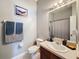 Bathroom featuring a vanity sink, toilet and shower with blue decorative towels at 7624 Red Mill Cir, New Port Richey, FL 34653
