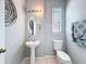 Bathroom with pedestal sink, decorative mirror, and natural light at 7624 Red Mill Cir, New Port Richey, FL 34653