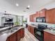 This modern kitchen features wood cabinets, stainless steel appliances and a breakfast bar at 7624 Red Mill Cir, New Port Richey, FL 34653