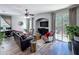 Open-concept living room with a ceiling fan, modern furniture, and large sliding glass doors at 7624 Red Mill Cir, New Port Richey, FL 34653