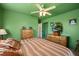 Cozy green bedroom with a ceiling fan, striped bedding, and natural light from two windows at 7901 Willow Brook Ct, Hudson, FL 34667