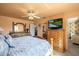 Comfortable bedroom with neutral tones, ceiling fan and large TV screen on a wooden dresser at 7901 Willow Brook Ct, Hudson, FL 34667