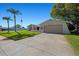 Charming single-story home featuring a two-car garage, desert landscaping, and an American flag at 7901 Willow Brook Ct, Hudson, FL 34667