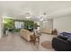 Spacious living room boasting tile floors, a ceiling fan, and multiple seating areas at 7901 Willow Brook Ct, Hudson, FL 34667