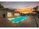 Inviting pool area with brick patio, poolside seating, and stunning sunset views at 7901 Willow Brook Ct, Hudson, FL 34667