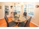 Bright breakfast nook features a glass table, four chairs, and large windows for natural light and view of the lanai at 8609 Regal Ln, Hudson, FL 34667