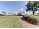 Spacious yellow clubhouse with white trim and a manicured green lawn with an American flag in the foreground at 8609 Regal Ln, Hudson, FL 34667
