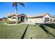 Beautifully maintained single-story home featuring a manicured lawn and picturesque landscaping at 8609 Regal Ln, Hudson, FL 34667
