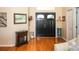 Welcoming foyer with dark double doors, wood floors, and decorative accents at 8609 Regal Ln, Hudson, FL 34667