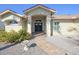 Inviting entryway with black double doors, stone pathway, decorative shrubbery, and charming bird bath at 8609 Regal Ln, Hudson, FL 34667