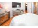 Elegant main bedroom with hardwood floors, neutral color scheme, tufted headboard, and mirrored bedside tables and dressers at 8609 Regal Ln, Hudson, FL 34667