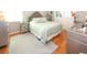 Elegant main bedroom with hardwood floors, neutral color scheme, tufted headboard, and mirrored bedside tables and dressers at 8609 Regal Ln, Hudson, FL 34667