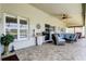 Screened-in patio featuring brick flooring, ceiling fan and comfortable furniture at 8609 Regal Ln, Hudson, FL 34667