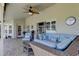 Outdoor patio with blue cushioned wicker seating, brick flooring and ceiling fan at 8609 Regal Ln, Hudson, FL 34667