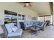 Covered patio with brick flooring, ceiling fan, comfortable wicker seating and glass topped table at 8609 Regal Ln, Hudson, FL 34667