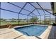Screened in pool area with brick patio surrounded by lush landscaping and a golf course at 8609 Regal Ln, Hudson, FL 34667