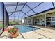 Screened in pool area with brick patio and outdoor furniture under a shaded roof at 8609 Regal Ln, Hudson, FL 34667